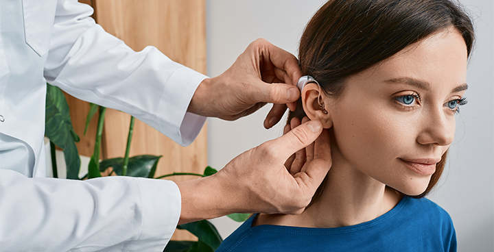 audiometrista testa apparecchio acustico su un paziente